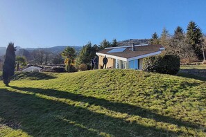 Ein modernes Haus mit Satteldach, Solaranlage und gepflegtem Rasen.