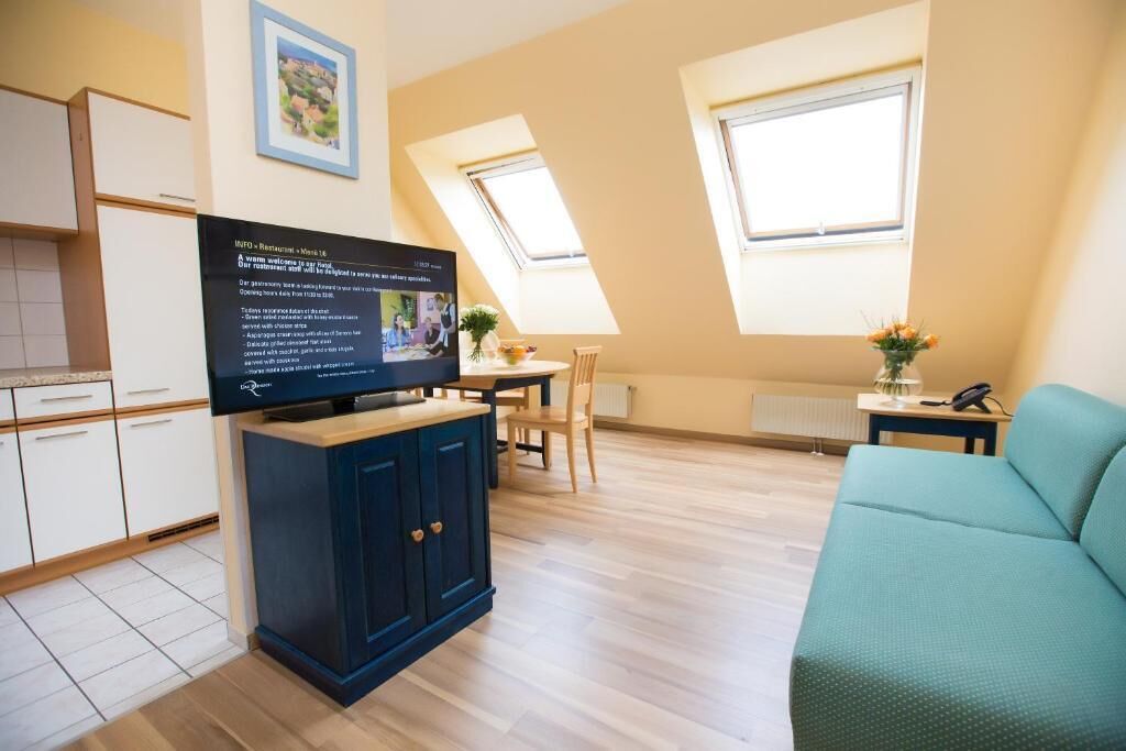 Ein modernes Apartment mit Fernseher, Essbereich und Sofa.