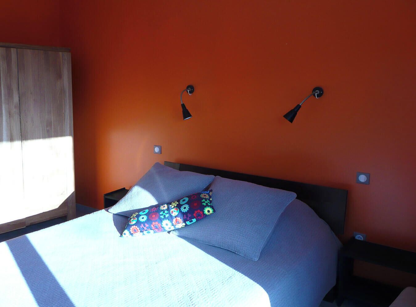 Une chambre avec un lit, une table de chevet et une fenêtre avec des rideaux.