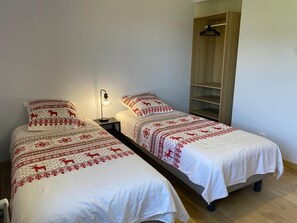 A bedroom with two single beds, a bedside table with a lamp, and a wardrobe. - The Three Som - SAINT PIERRE DE CHARTREUSE (SAINT PIERRE DE CHARTREUSE)