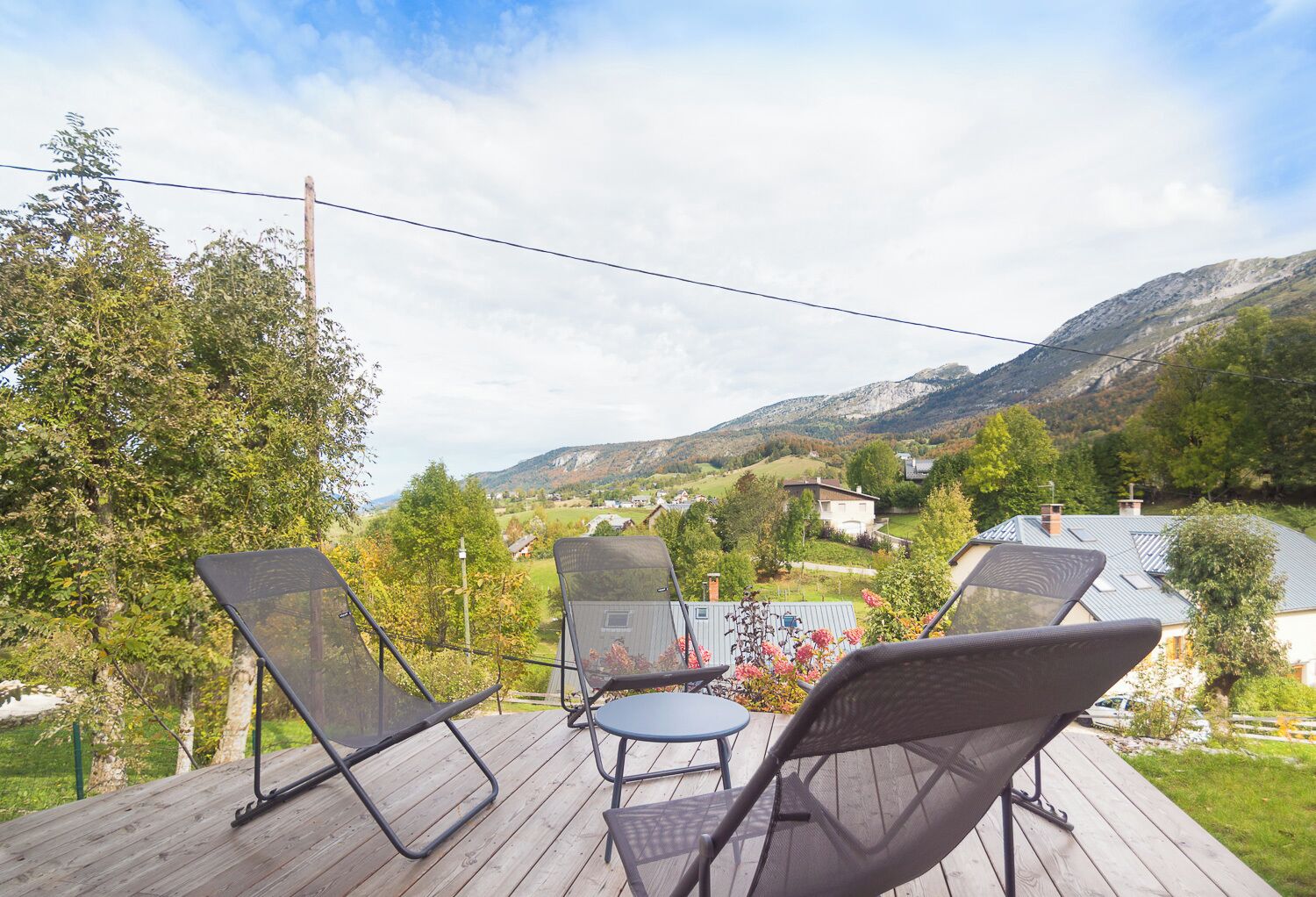 Eine Terrasse mit Gartenmöbeln mit Blick auf eine Berglandschaft.