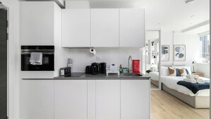 Eine moderne Küche mit weißen Schränken, einem eingebauten Backofen und einer Arbeitsplatte mit diversen Gegenständen.