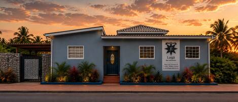 Un edificio de dos pisos con un cartel que indica que es una casa de huéspedes llamada 'Lugá Bed & Breakfast'.
