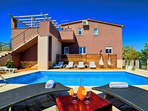 A modern building with a swimming pool, outdoor seating, and a staircase leading to an upper level. - Villa Nikolina by Interhome (Pula/Banjole)