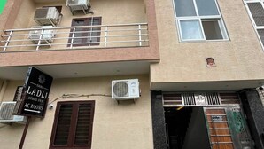 A multi-story building with a sign for 'Shri Ladli Stays Inn AC Rooms' indicating the presence of air conditioning units and a gated entrance. - Shri Ladli Stays Inn (Vrindavan)