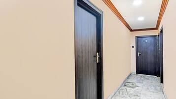 A hallway with two doors, one with a visible handle and the other with a visible lock.