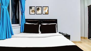 A bedroom with a bed, a nightstand, and three wall-mounted artworks.