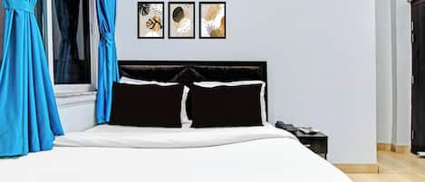 A bedroom with a bed, a nightstand, and three wall-mounted artworks.