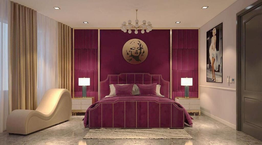A bedroom with a large bed, two bedside tables, a chair, and a chandelier.