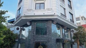 Un edificio en esquina con el letrero 'THE WILTONS', una placa negra y un balcón.