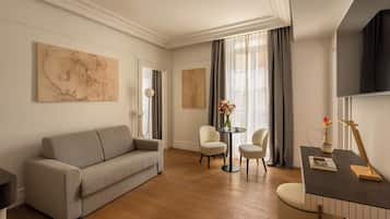 Ein modernes Wohnzimmer mit einer Couch, zwei Sesseln, einem kleinen Tisch und Kunstwerken an den Wänden.