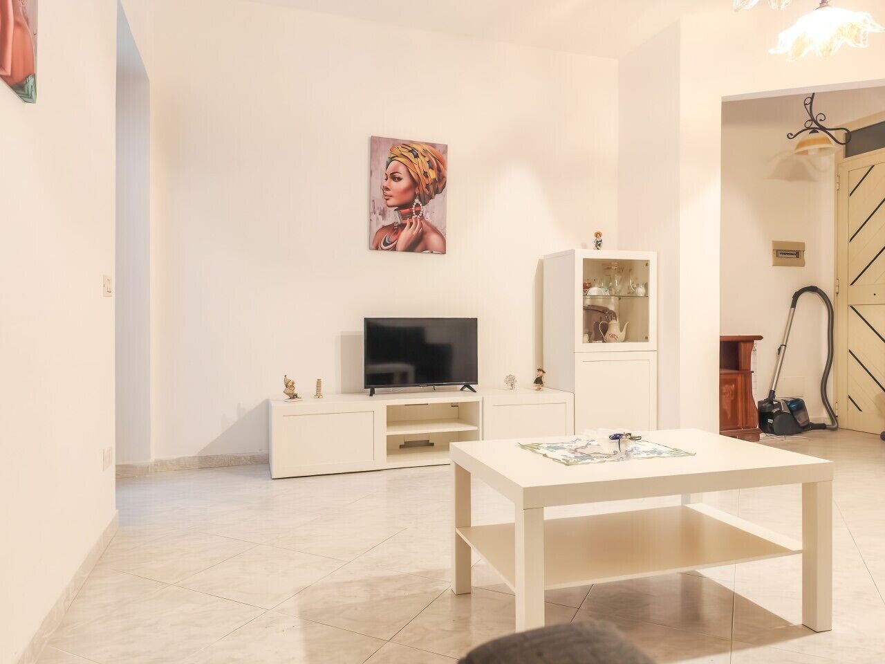 Una sala de estar moderna con un televisor de pantalla plana, una mesa de centro y un cuadro en la pared.