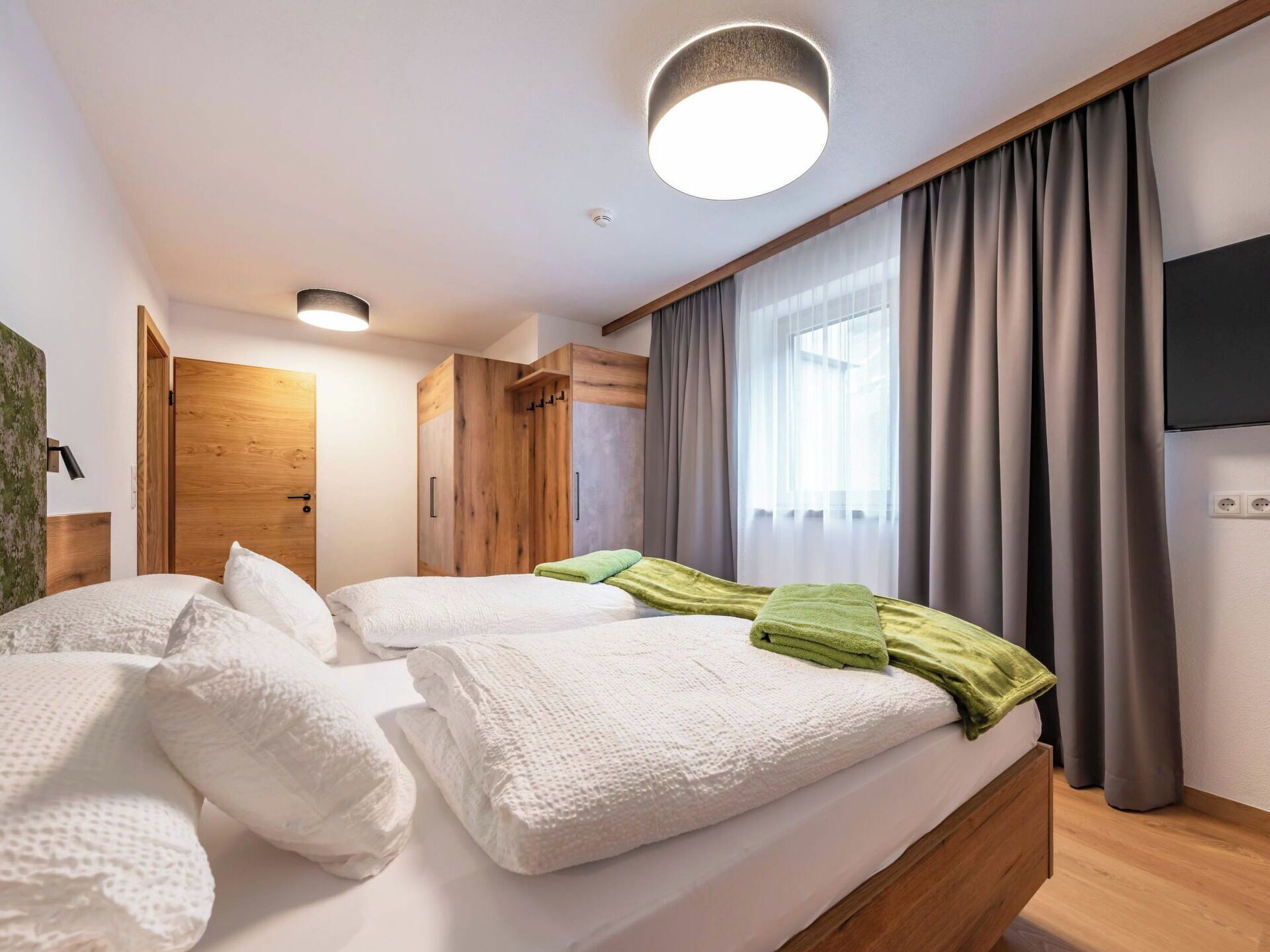 Une chambre à coucher avec un lit, une armoire en bois et un luminaire au plafond.