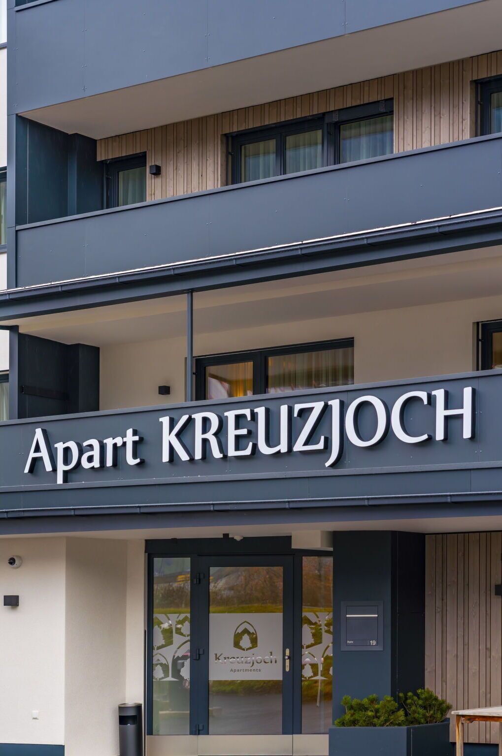 A building with a sign reading 'Apart KREUZJOCH Apartments.'