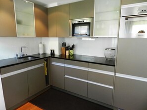 A modern kitchen with a built-in oven, a sink, and a dishwasher. - Ladina 34 Appartement/Fewo, Dusche oder Bad, WC 2½-Zimmerwohnung by Interhome (Davos)