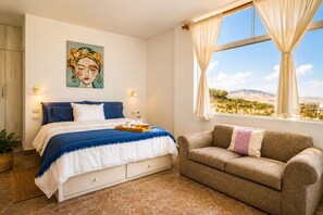 A bedroom with a bed, a sofa, a painting, and a window with a view. - Casa con Vista al Mar cerca a Punta Hermosa 16B LPN 5 (Punta Negra)