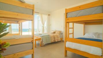 Una habitación con dos literas, una mesita y una ventana con cortinas.