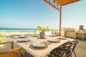 An outdoor dining area with a table set for four, overlooking a coastal view. - Casa con Vista al Mar cerca a Punta Hermosa 16B LPN 5 (Punta Negra)
