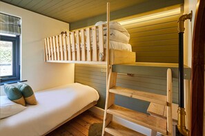 A bunk bed with a wooden ladder, a window with blinds, and a bedside table with a lamp. - Host & Stay | Casa Formentera (Scarborough)