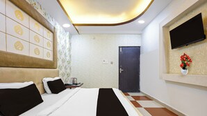 Ein Hotelzimmer mit Bett, Schreibtisch, Fernseher und einer Tür.
