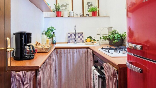 A compact kitchen with a red refrigerator, a coffee maker, and various kitchen utensils. - Stone cottage with view of Gubbio and shared pool (Gubbio)