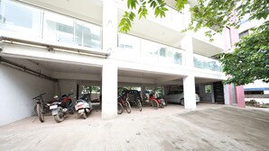 A multi-level parking structure with several motorcycles and cars parked. - Hotel Alt Acco close to Kharadi (Pune)