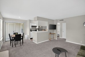 Eine moderne Wohnung mit Essbereich, Küchenzeile und Wohnraum.