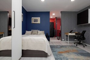 Ein modernes Schlafzimmer mit einem Bett, einem Schreibtisch und einem Stuhl.