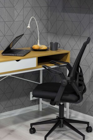 A modern office setup with a laptop, a desk lamp, a mug, and a black office chair. - Stylish Studio for 2 Guests in Warsaw with Remote Work Space by Noclegi Renters (Warszawa)