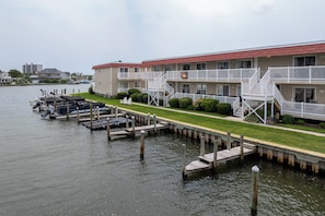 A waterfront motel with a dock, boats, and a grassy walkway. - Relax and Unwind on the Bay in North Ocean City (Ocean City)