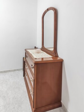 A wooden dresser with a mirror and drawers against a white wall. - Casa Vacanze - Mare and Joy. (Castelvetrano)