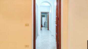 Un pasillo con un interruptor de luz y una puerta que da a otra habitación.