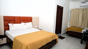 Una habitación de hotel con cama, mesita de noche y armario.