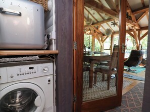 A laundry area with a washing machine, dryer, and stacked items. - Cool Cabin (Leek)