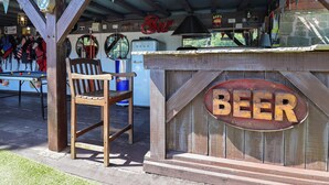 A rustic outdoor bar area with a wooden sign reading 'BEER' and a 'HAPPY HOUR' sign above. - Cool Cabin (Leek)