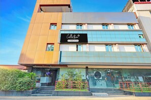 A multi-story building with a prominent sign indicating it is a company-serviced location. - Super OYO Collection O Vizag (Visakhapatnam)