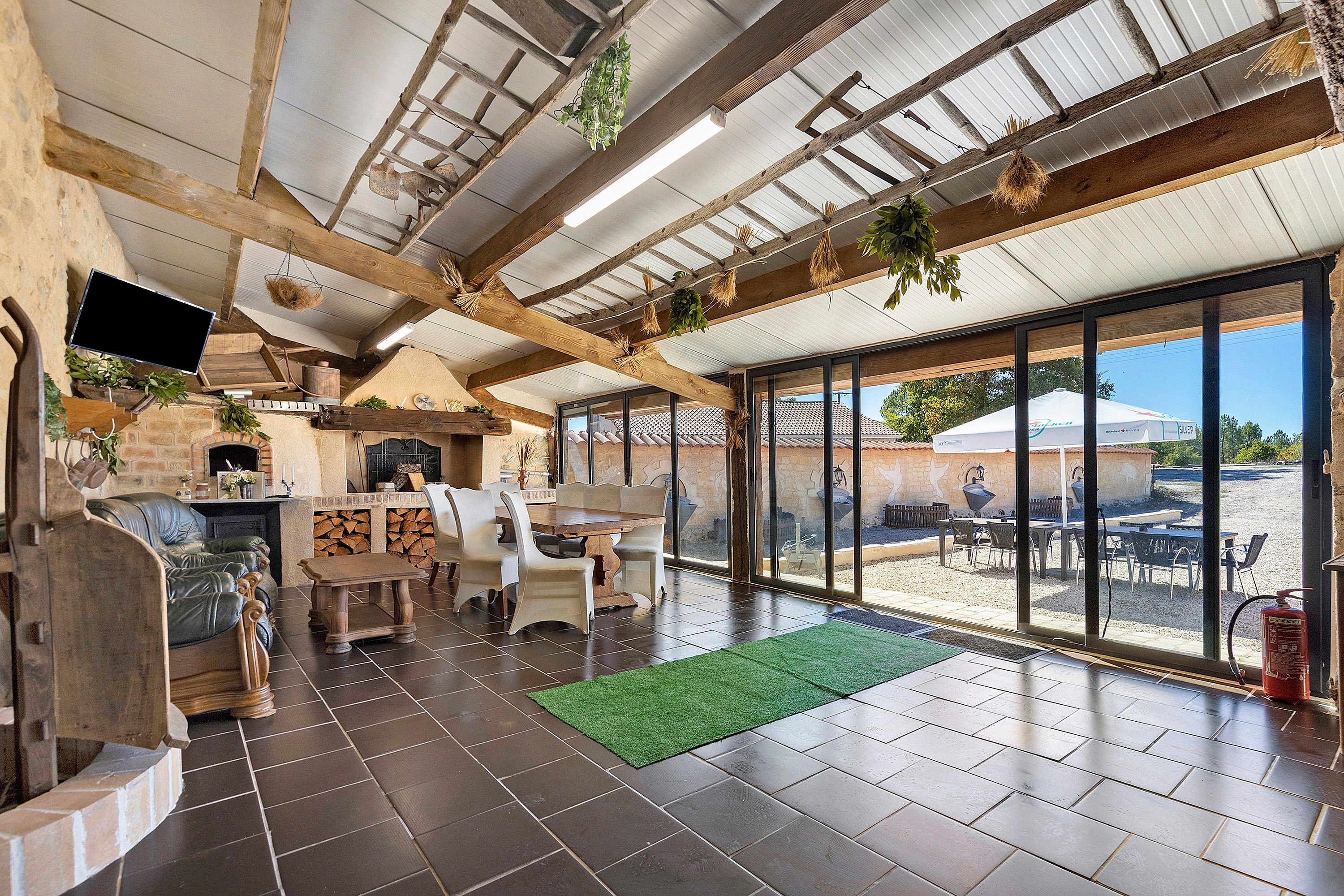 Ein großzügiger Patio-Bereich mit Kamin, Sitzgelegenheiten im Freien und Blick auf die umliegende Landschaft.