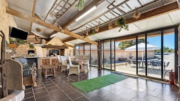 A spacious patio area with a fireplace, outdoor seating, and a view of the surrounding landscape.