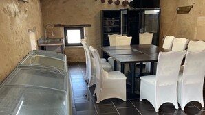 A restaurant with a long counter, white chairs, and a tiled floor.