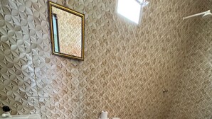 Un baño con inodoro, lavabo y zona de ducha.