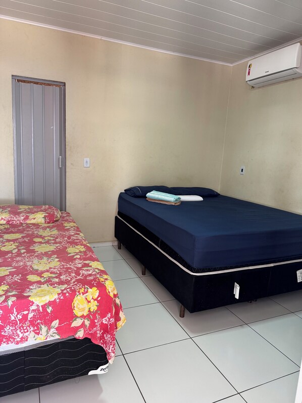 A room with a bed, a wardrobe, and an air conditioning unit. - HOTEL POUSADA JESUS ME DEU (Iguatu)