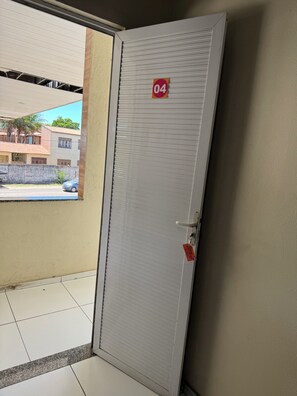 A closed door with a number sign, a metal handle, and a key lock. - HOTEL POUSADA JESUS ME DEU (Iguatu)