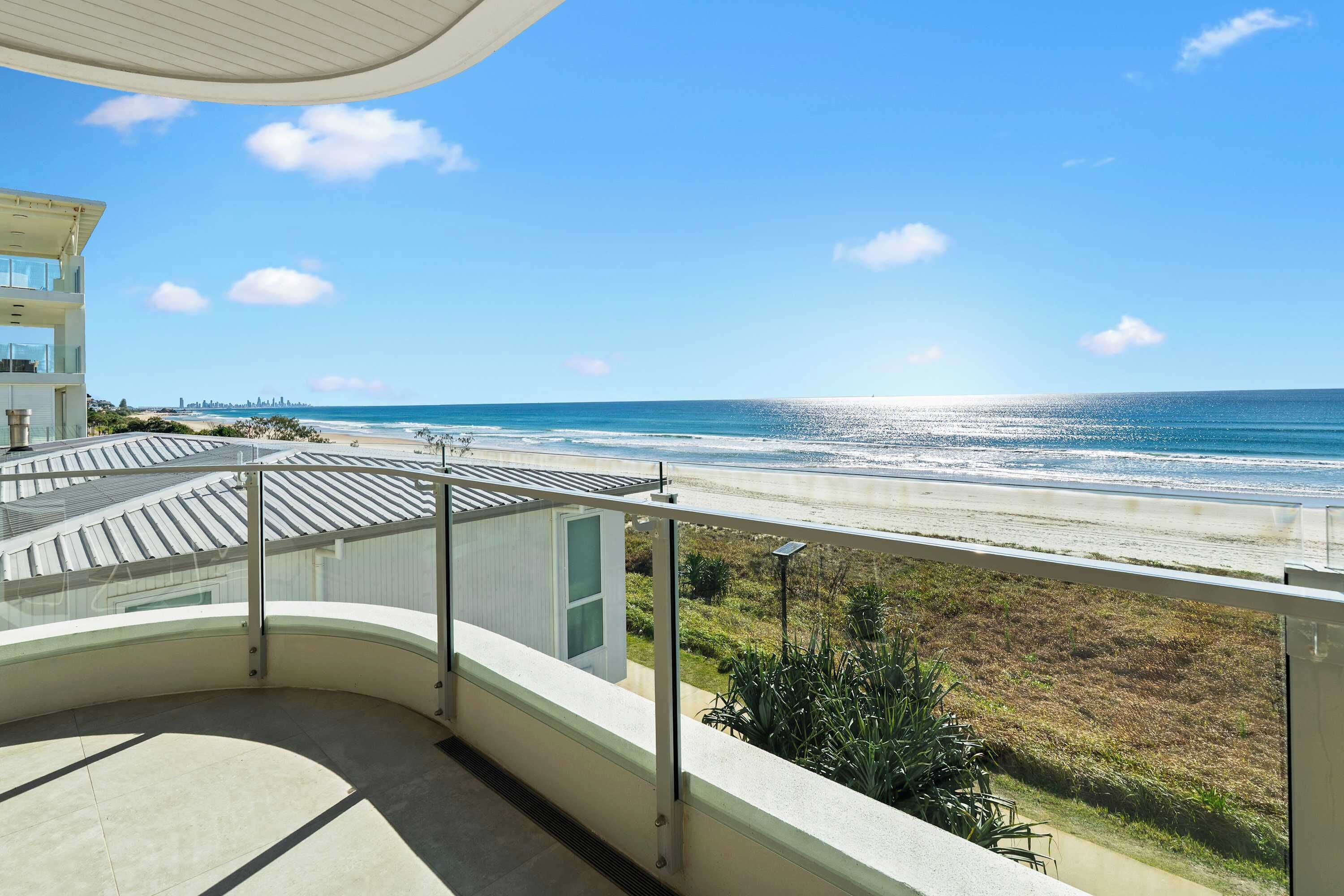 Een balkon met uitzicht op het strand en de oceaan.