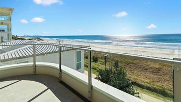 Een balkon met uitzicht op het strand en de oceaan.