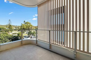 Ein Balkon mit Blick auf einen Parkplatz und Bäume.