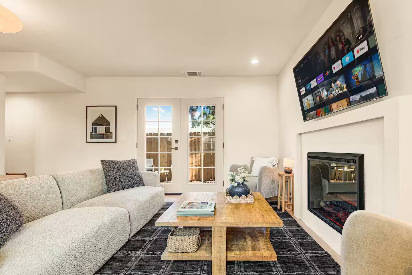 A modern living room with a sofa, coffee table, and fireplace.