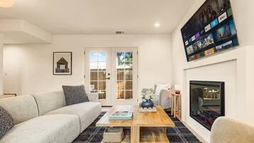 A modern living room with a sofa, coffee table, and fireplace.
