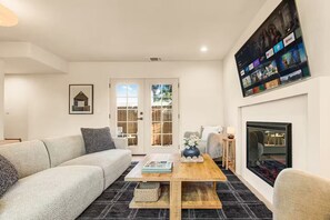 A modern living room with a sofa, coffee table, and fireplace.