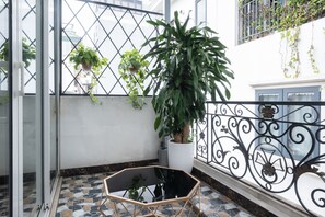 A balcony with a potted plant, a glass table, and a tiled floor. - Hanoi Bliss Hotel & Apartment Phat Loc (Hanoi)