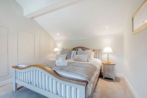 Un dormitorio con cama, mesitas de noche y un espejo.